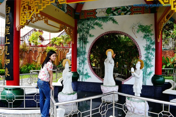 My wife posing with three sculptures in Cebu Taoist Temple